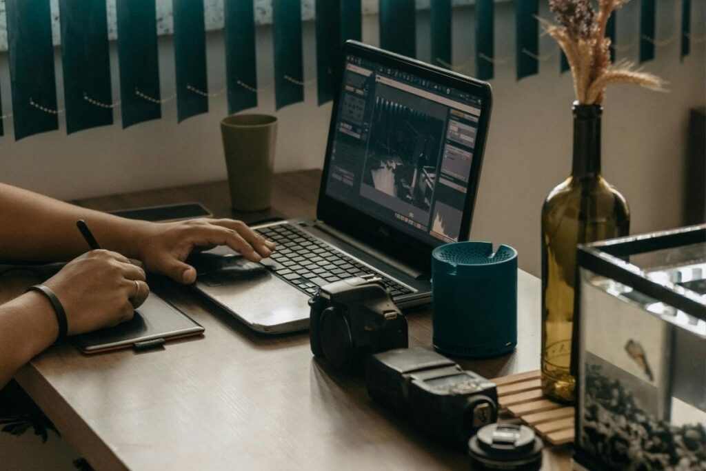 Freelancer bei der digitalen Arbeit mit Laptop und Kamera