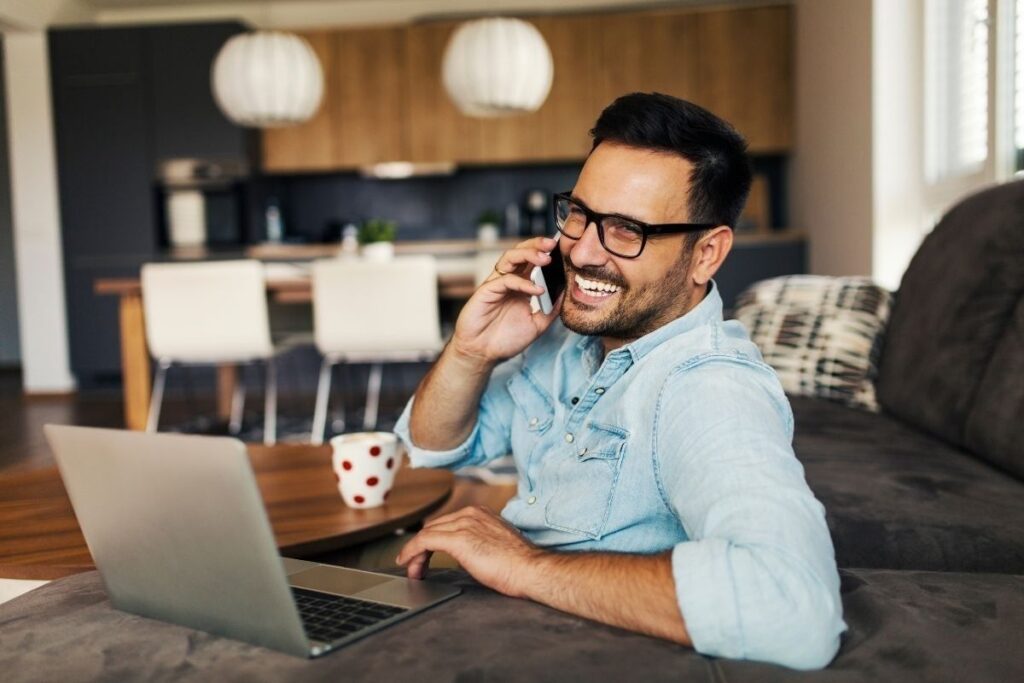 Freelancer telefoniert während der Arbeit am Laptop
