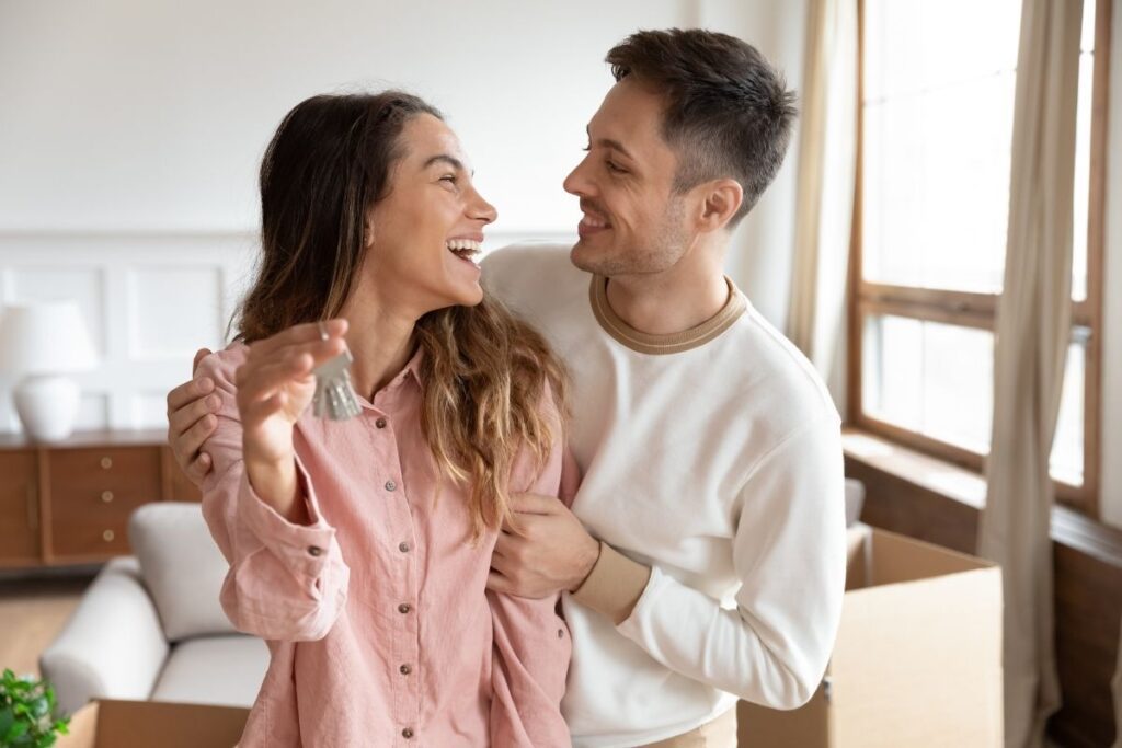 Buy apartment in Dubai happy couple holding keys after successful purchase