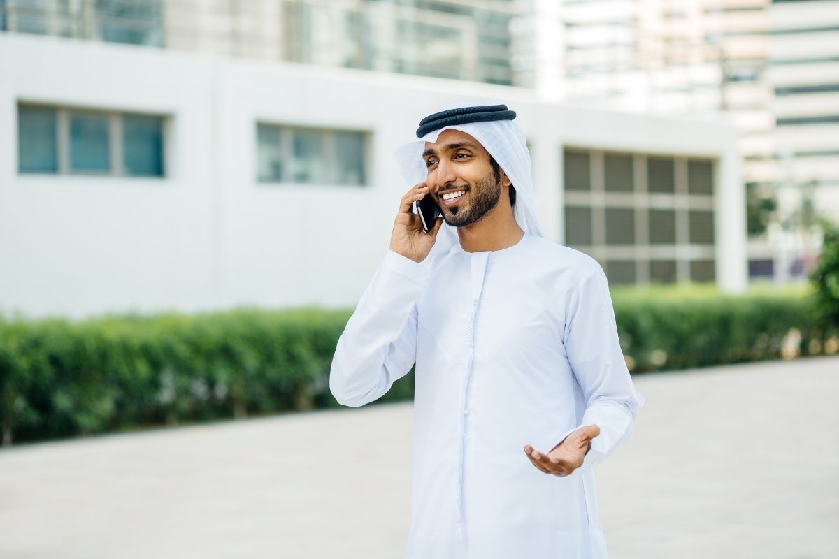 Work in Dubai businessman talking on phone outside modern office buildings