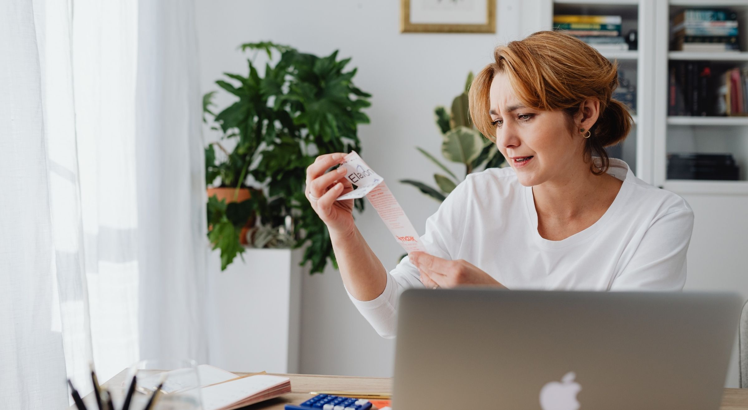 Cost of living in Dubai daily expenses – woman reviewing bills for rent, groceries and living costs in the UAE