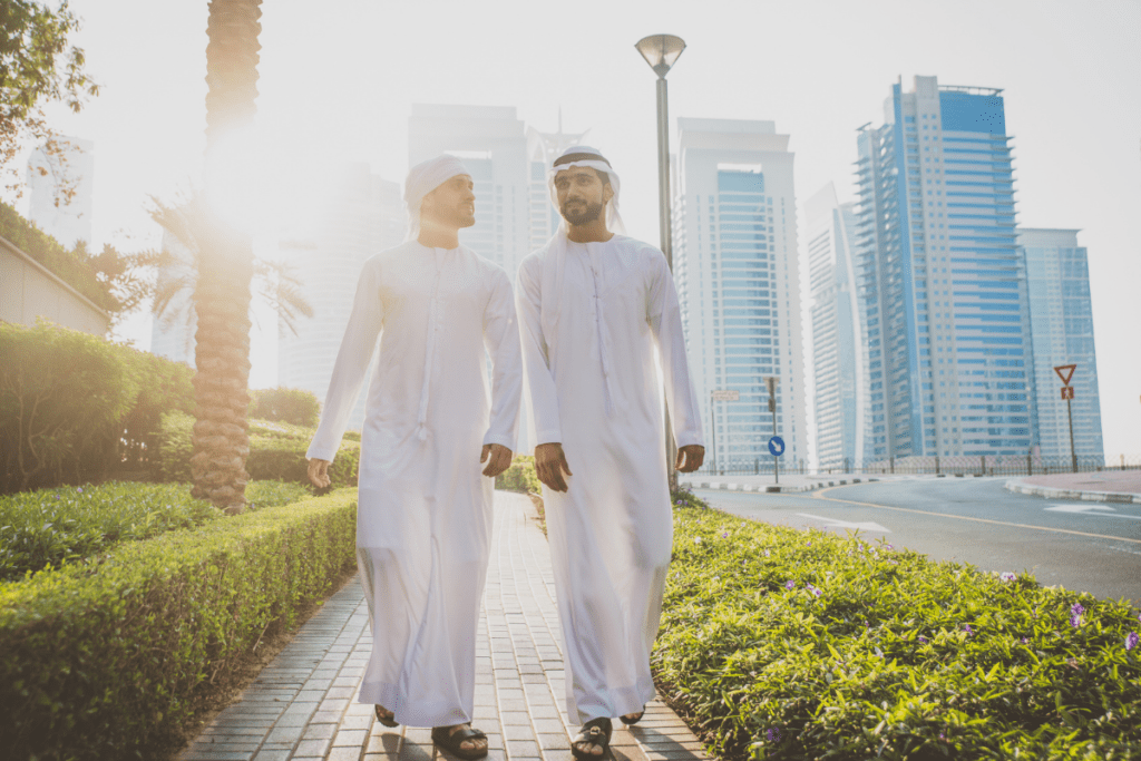 Men walking through modern streets in Dubai with skyscrapers in the background