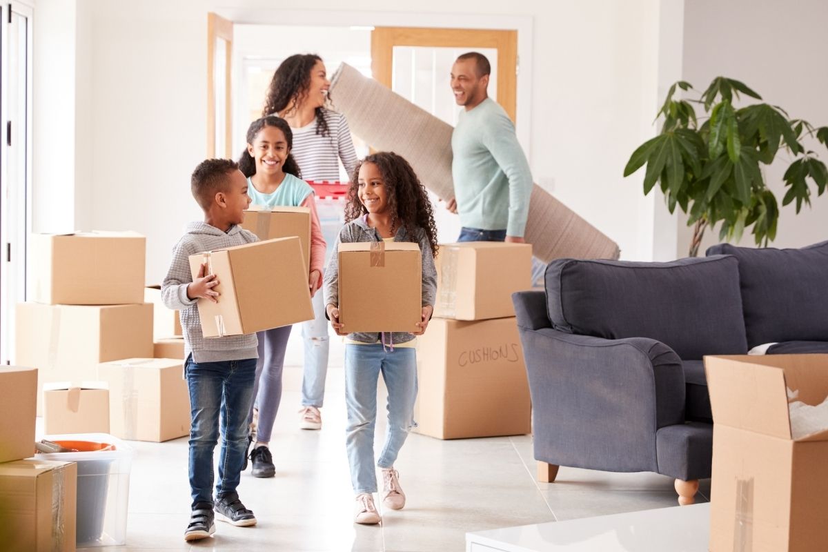 Family moving to Dubai carrying boxes into their new home