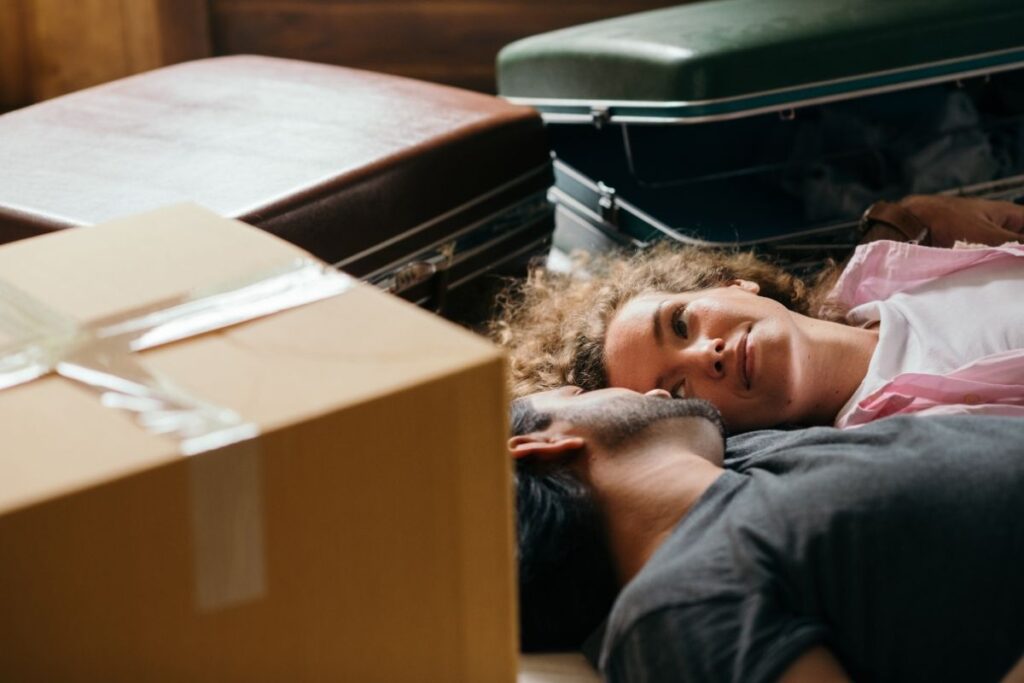 Couple resting among moving boxes after relocating to Dubai