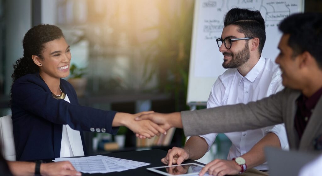 Bewerber und Arbeitgeber geben sich die Hand beim Vorstellungsgespräch für ein Arbeitsvisum Dubai