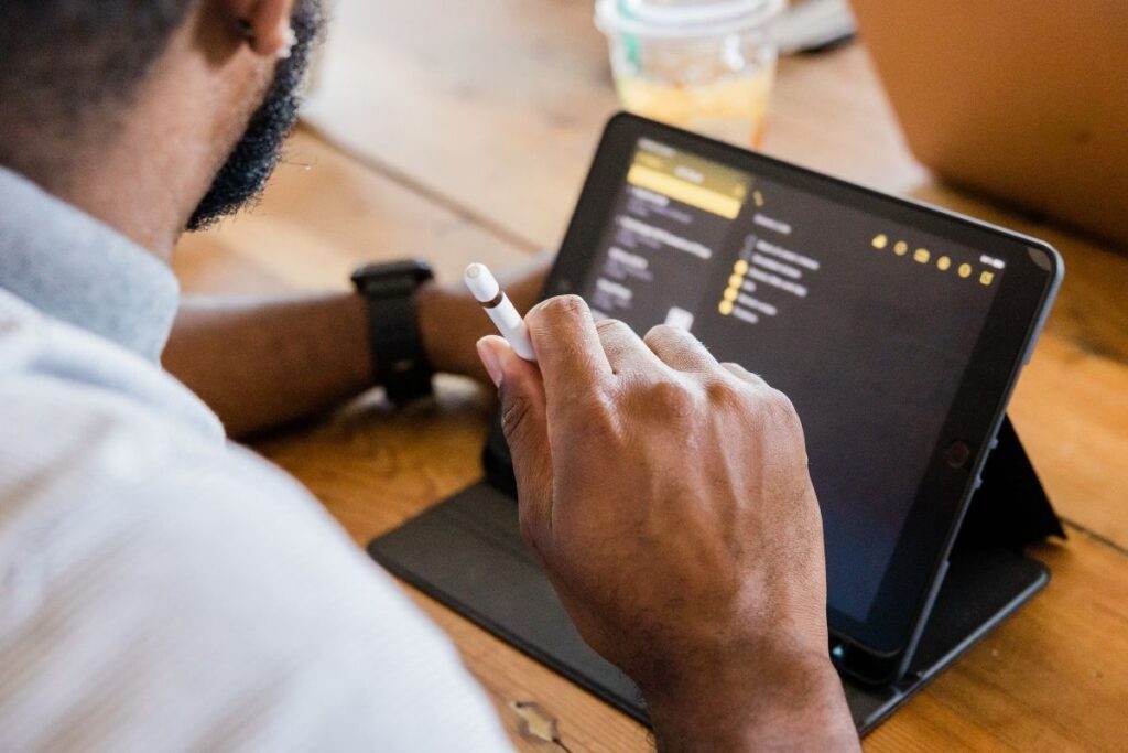 Person arbeitet mit Tablet an digitalen Projekten im Rahmen einer Tätigkeit mit Green Visa Dubai.